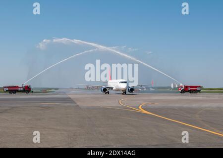 Wassergruß mit Feuerwehrauto am Flughafen zuerst Besuchen Sie Passagierflugzeuge Stockfoto