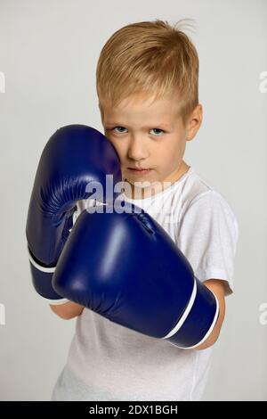 Porträt von kleinen Boxkämpfer Junge in blauen Boxer Handschuhe. Kind träumt davon, ein Boxchampion zu werden Stockfoto