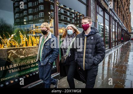 Großbritannien / England / London / EINE Familie mit Gesichtsmasken als Vorsichtsmaßnahme gegen das neuartige Coronavirus COVID-19 geht an Harrods vorbei. Stockfoto