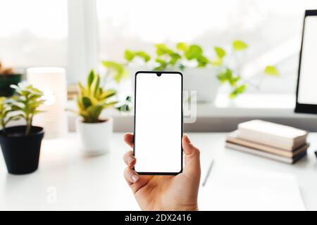 Smartphone in der Hand, Arbeit von zu Hause, Büromaterial Stockfoto