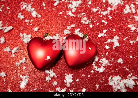 Rote Herzen auf rotem Hintergrund mit Schnee Stockfoto