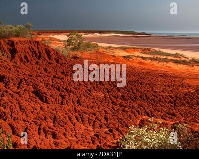 Ebbe unter roten Pindan-Klippen in Munget an der Pender Bay, Dampier Peninsula, Westaustralien Stockfoto