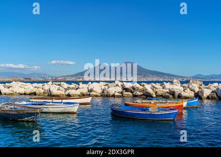 Blick auf Vulkan Vesuv Blick von der Küste mit bunten Booten im Vordergrund, Neapel, Kampanien, Italien. Stockfoto