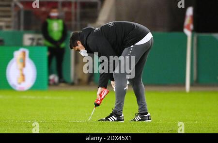 23. Dezember 2020, Baden-Württemberg, Stuttgart: Fußball: DFB Cup, VfB Stuttgart - SC Freiburg, 2. Runde in der Mercedes-Benz Arena. Ein Trainer reinigt das Spielfeld, nachdem ein Spieler geworfen hat. Wichtiger Hinweis: Der DFB verbietet die Verwendung von Sequenzbildern im Internet und in Online-Medien während des Spiels (einschließlich Halbzeit). Sperrfrist. Das DFB erlaubt die Veröffentlichung und Weiterverwendung der Bilder auf mobilen Geräten (insbesondere MMS) und über DVB-H und DMB erst nach Ende des Spiels). Foto: Marijan Murat/dpa - WICHTIGER HINWEIS: Gemäß den Vorschriften der DFL Deutsche Fußba Stockfoto