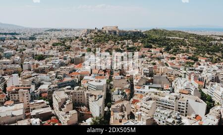 Luftdrohne Aufnahme des schönen Akropolis-Denkmals auf dem Hügel von Athen während des heißen Sommertages. Stockfoto