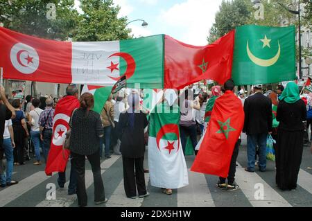 Demonstranten schwenken algerische, marokkanische, tunesische und palästinensische Fahnen und halten Plakate während einer pro-palästinensischen Demonstration in Paris, Frankreich, am 2. August 2014. Israel bombardierte Gaza am Samstag, nachdem es die Hamas beschuldigte, einen humanitären Waffenstillstand zerstört zu haben, indem es einen Soldaten gefangennimmt, von dem die Islamisten sagen, dass er wahrscheinlich beim israelischen Beschuss getötet wurde. Foto von Alain Apaydin/ABACAPRESS.COM Stockfoto