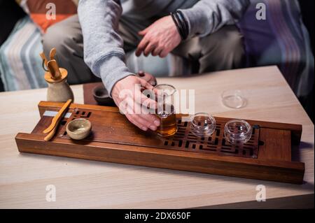 Rezept für die Herstellung von köstlichen schwarzen Tee nach chinesischen Traditionen. Nahaufnahme von Glas- und Tongeschirr für Tee. Kolben und Wasserkocher Stockfoto