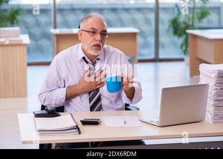 Der Angestellte eines alten Geschäftsmannes war mit übermäßiger Arbeit unzufrieden Stockfoto
