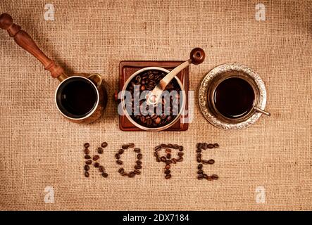 Geröstete Kaffeebohnen in Buchstaben angeordnet Kaffee auf russisch. Stockfoto