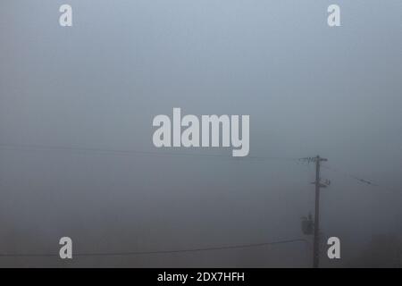 Tzoumerka, Epirus, Griechenland - 15. Dezember 2017: Stromleitungen im Nebel Stockfoto