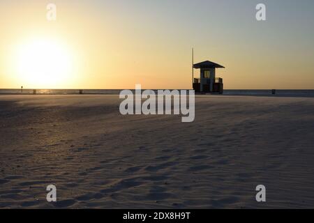 Rettungsschwimmer stehen am Strand bei Sonnenuntergang mit der Bewegung des Windes weht den Sand. Hintergrund. Speicherplatz kopieren. Clearwater Beach, Tampa, Florida, USA Stockfoto