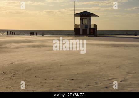 Rettungsschwimmer stehen am Strand bei Sonnenuntergang mit der Bewegung des Windes weht den Sand. Hintergrund. Speicherplatz kopieren. Clearwater Beach, Tampa, Florida, USA Stockfoto