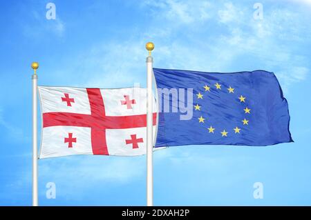 Georgien und die Europäische Union zwei Flaggen auf Fahnenmasten und blau Himmel Stockfoto