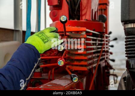 Die Bedienhand an den Steuerhebeln des Hydraulikkrans Stockfoto
