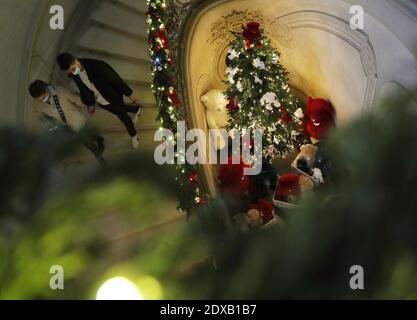 Paris, Frankreich. Dezember 2020. Maskierte Menschen gehen an Weihnachtsdekorationen im Schloss Chantilly, nördlich von Paris, Frankreich, vorbei, 23. Dezember 2020. Kredit: Gao Jing/Xinhua/Alamy Live Nachrichten Stockfoto