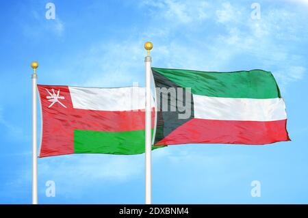 Oman und Kuwait zwei Flaggen auf Fahnenmasten und blauer Himmel Stockfoto