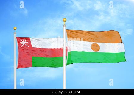Oman und Niger zwei Flaggen auf Fahnenmasten und blauer Himmel Stockfoto