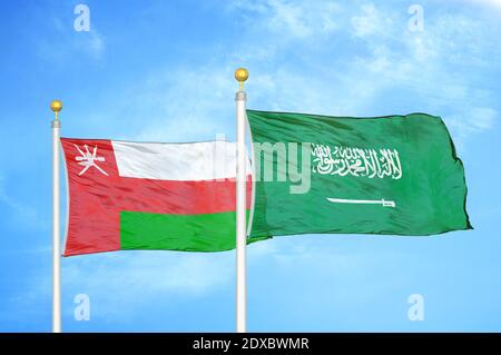 Oman und Saudi-Arabien zwei Flaggen auf Fahnenmasten und blau Himmel Stockfoto