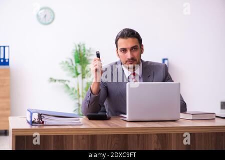 Männlicher Mitarbeiter, der Flash-Laufwerk in den Laptop einsteckt Stockfoto