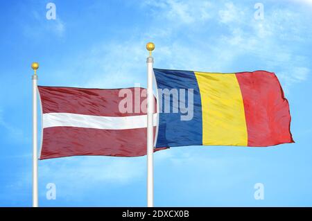 Lettland und Tschad zwei Flaggen auf Fahnenmasten und blauer Himmel Stockfoto