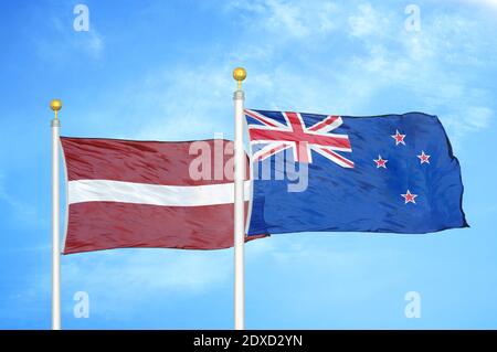 Lettland und Neuseeland zwei Flaggen auf Fahnenmasten und blau Himmel Stockfoto