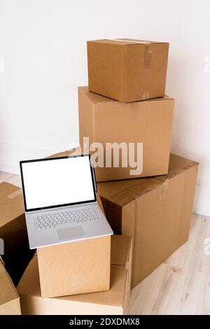 Laptop auf Karton im neuen Haus Stockfoto