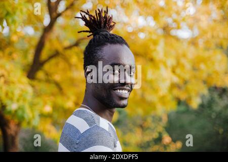 Stilvoller Mann von gelbem Baum im Park im Herbst Stockfoto