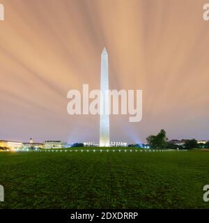 USA, Washington DC, Wolkenverhangener Himmel über Rasen vor dem Washington Monument in der Abenddämmerung Stockfoto