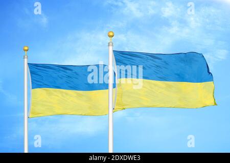 Ukraine zwei Flaggen auf Fahnenmasten und blauer Himmel Stockfoto