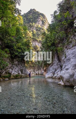 Mann, der in Acheron Fluss durch Berg bei Epirus, Griechenland steht Stockfoto