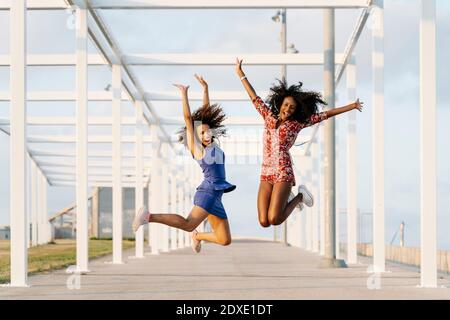 Unbeschwerte junge Freundinnen springen Stockfoto