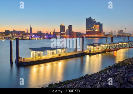 Deutschland, Hamburg, nördliches Elbufer bei Sonnenaufgang mit Elbphilharmonie und Skyline im Hintergrund Stockfoto