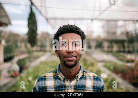 Junger afrikanischer männlicher Bauer in der Pflanzenkinderei Stockfoto