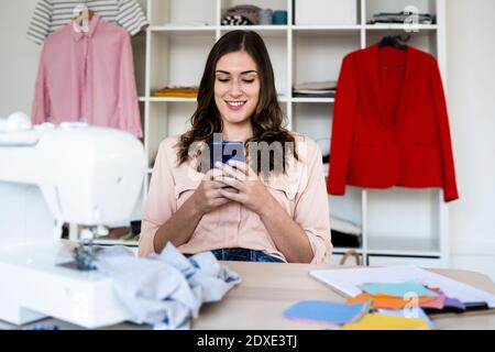 Schöne weibliche kreative professionelle mit Smartphone im Studio Stockfoto