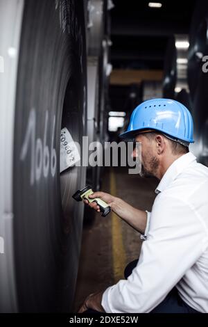 Geschäftsmann Scannen Barcode auf Stahlrollen, während in der Industrie stehen Stockfoto