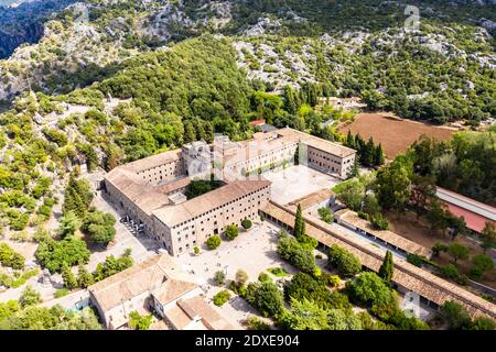 Spanien, Balearen, Escorca, Hubschrauberansicht von Santuari de Lluc im bewaldeten Tal der Serra de Tramuntana Range Stockfoto