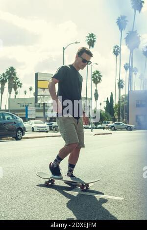 Junger Mann Skateboarding auf der Straße in der Stadt Stockfoto