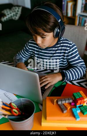 Vorpubertär Junge mit Laptop während der häuslichen Schooling Stockfoto