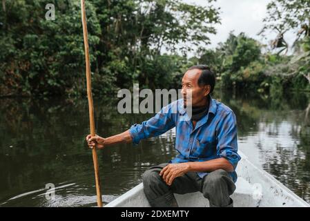 Senior Guarani Mann sitzt im Kanu am Napo River, Ecuador Stockfoto