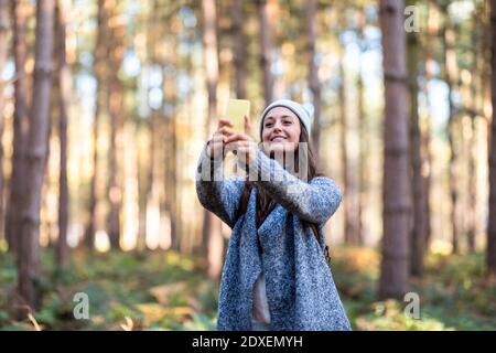 Lächelnde Wanderin, die im Stehen Selfie durch das Smartphone nimmt In Cannock Chase Woodland Stockfoto