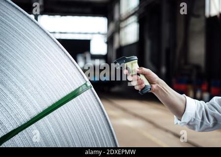 Man's Hand Scannen Barcode auf Stahlrollen in der Industrie Stockfoto