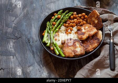 Schüssel Reis mit Kichererbsen, Spargelstielen und gebratenem Halloumi-Käse Stockfoto