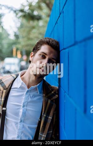 Portrait von stilvollen Mann gegen blaue Wand lehnt Stockfoto