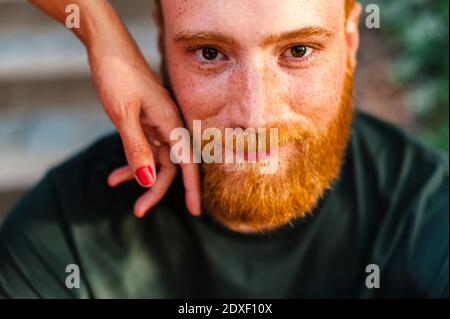 Die Hand der Freundin berührt das Gesicht des Freundes Stockfoto