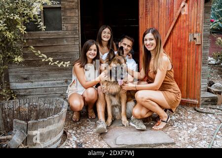Lächelnde Familie mit Hund im Hinterhof Stockfoto