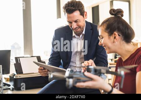 Geschäftsleute, die ein digitales Tablet verwenden, während sie mit Quadcopter AT arbeiten Büro Stockfoto