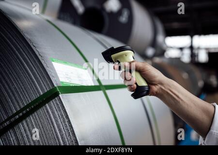 Man's Hand Scannen Barcode auf Stahlrollen in der Industrie Stockfoto
