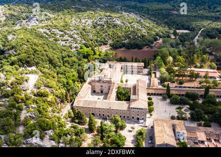 Spanien, Balearen, Escorca, Hubschrauberansicht von Santuari de Lluc im bewaldeten Tal der Serra de Tramuntana Range Stockfoto