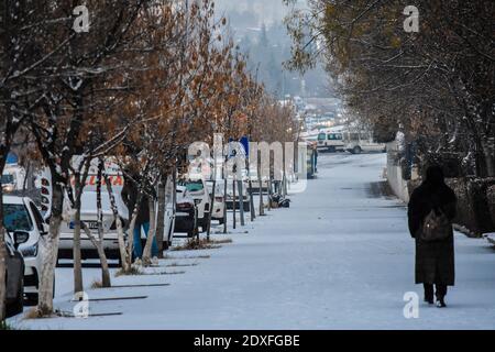 Ankara, Türkei. Dezember 2020. Eine Frau geht während des ersten Schneefalls in der Wintersaison auf einer verschneiten Straße. Kredit: Altan Gocher/ZUMA Wire/Alamy Live Nachrichten Stockfoto