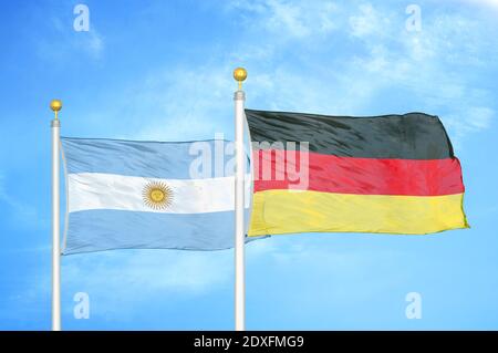 Argentinien und Deutschland zwei Flaggen auf Fahnenmasten und blauer Himmel Stockfoto